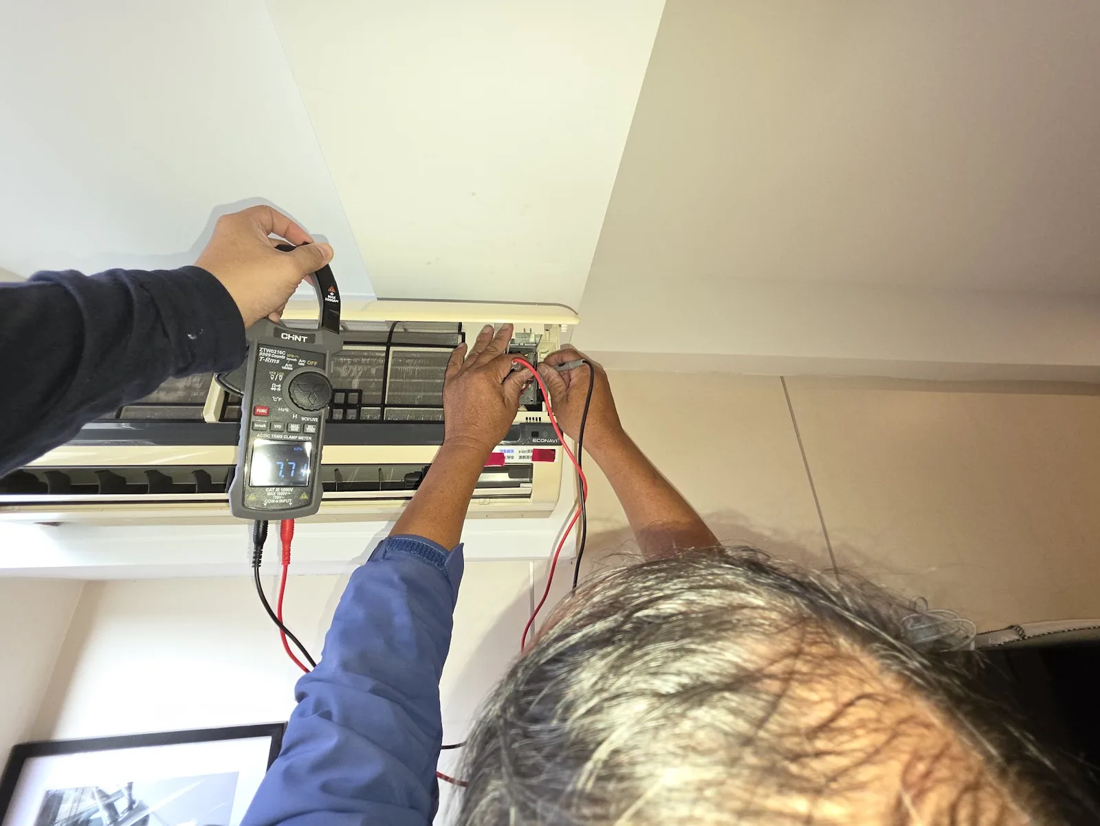現場人員以電表量測拆開外殼的冷氣室內機