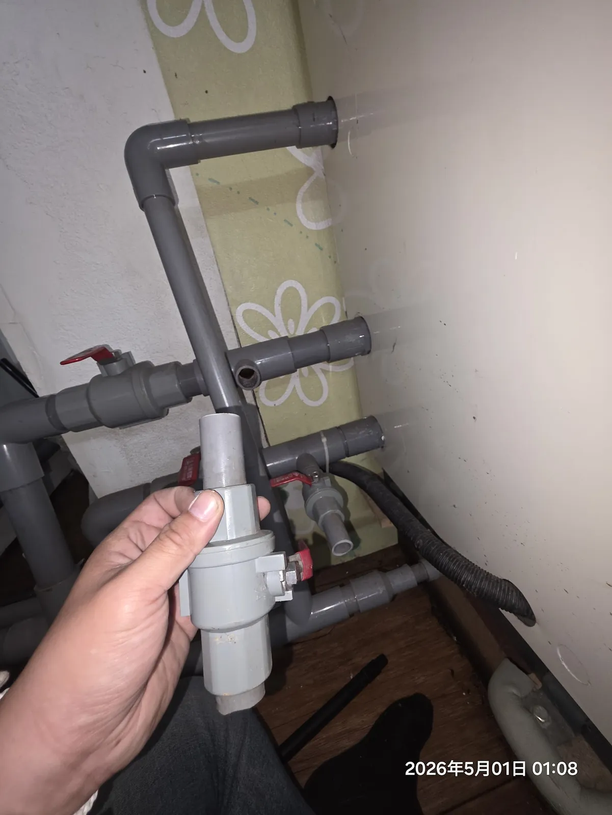 師傅手持更換用 PVC 閥件準備接回冷氣排水管