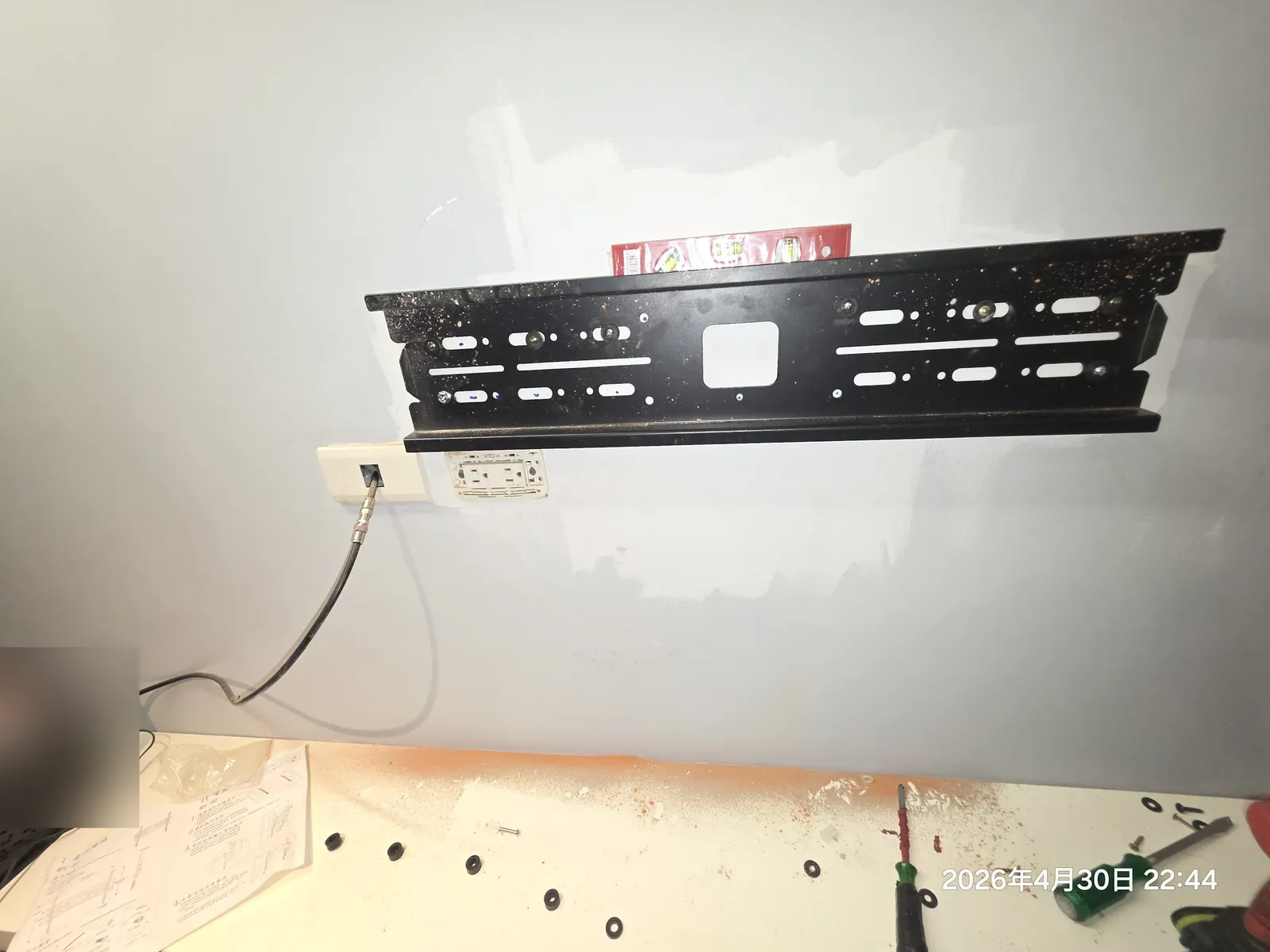 75吋電視壁掛架固定於牆面,下方保留插座位置