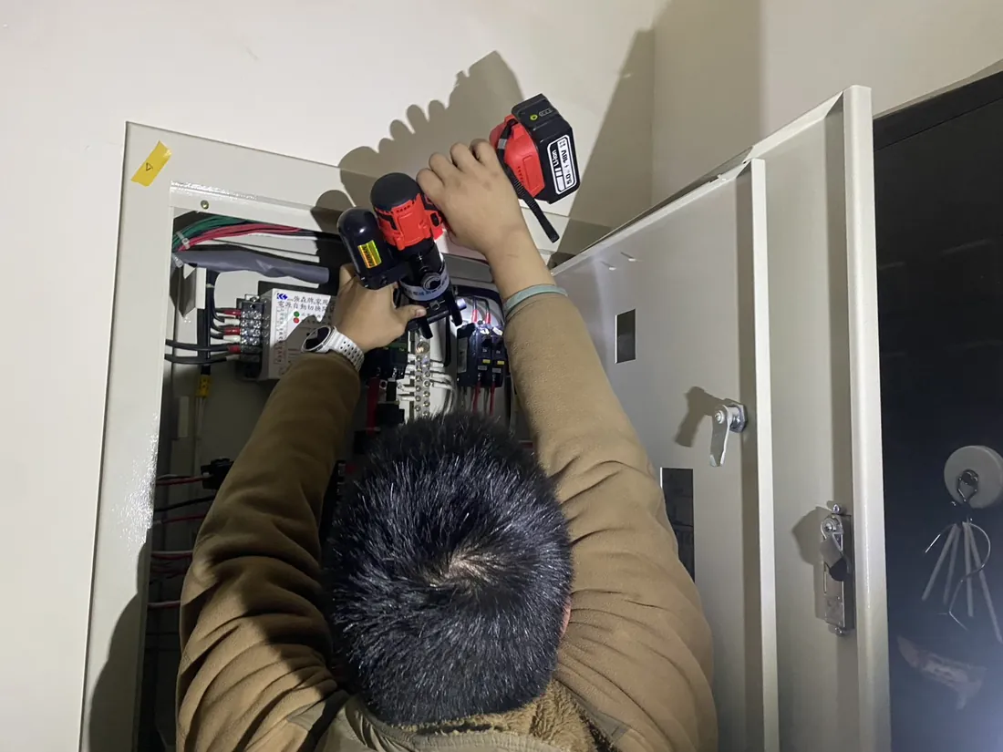 森麒師傅在配電箱內以電動壓接工具施作端子的現場實拍